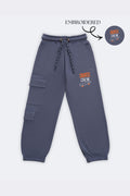 Denim blue track pants with dual cargo patch pockets and skate-crew embroidery
