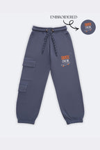 Denim blue track pants with dual cargo patch pockets and skate-crew embroidery