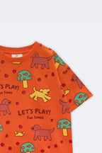 Orange kids comfort tee angled view with all-over animals and “Let’s Play!” print