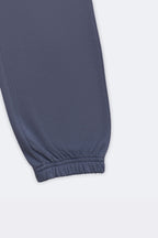 Denim blue track pants with ribbed ankle cuff and smooth jogger hem