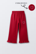 Red palazzo pants with wide legs, elastic waist, and heart embroidery