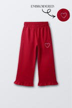 Red palazzo pants with wide legs, elastic waist, and heart embroidery