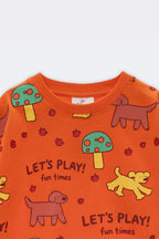 Orange kids tee close-up: “Let’s Play!” text with dogs, bugs, and mushroom icons