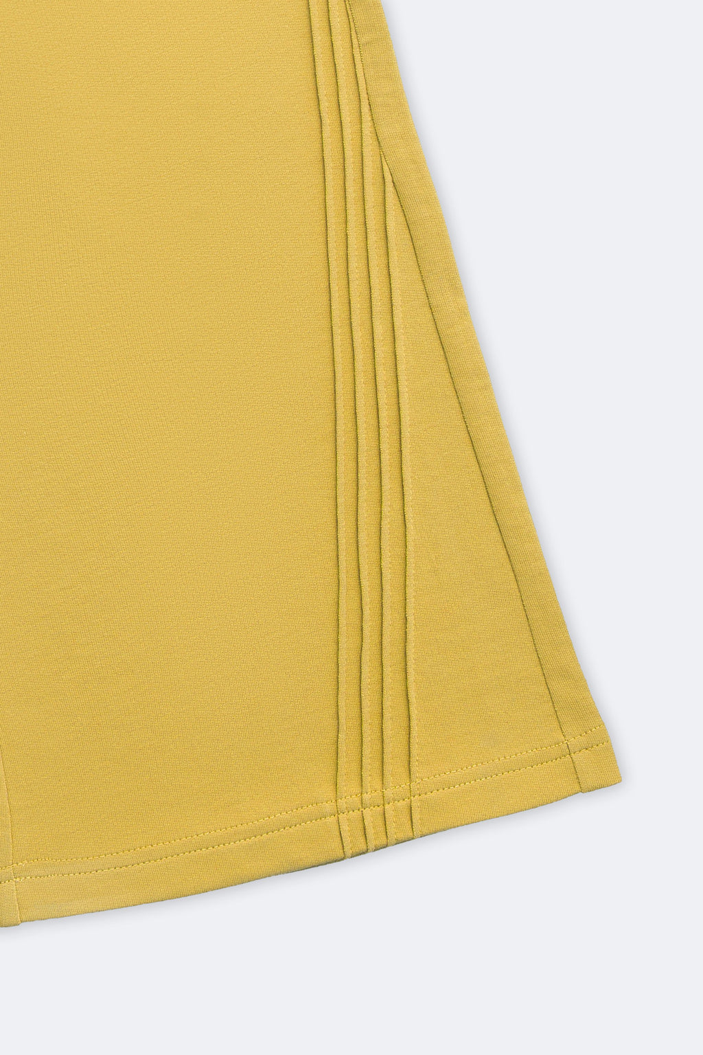 Yellow flared pant hem with vertical slant pintuck detailing and stitched edge
