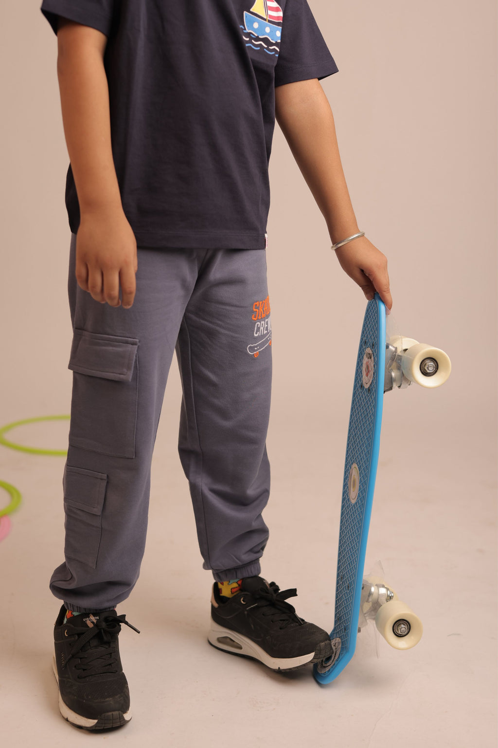Denim blue track pants with cargo patch pockets and skateboard-logo embroidery