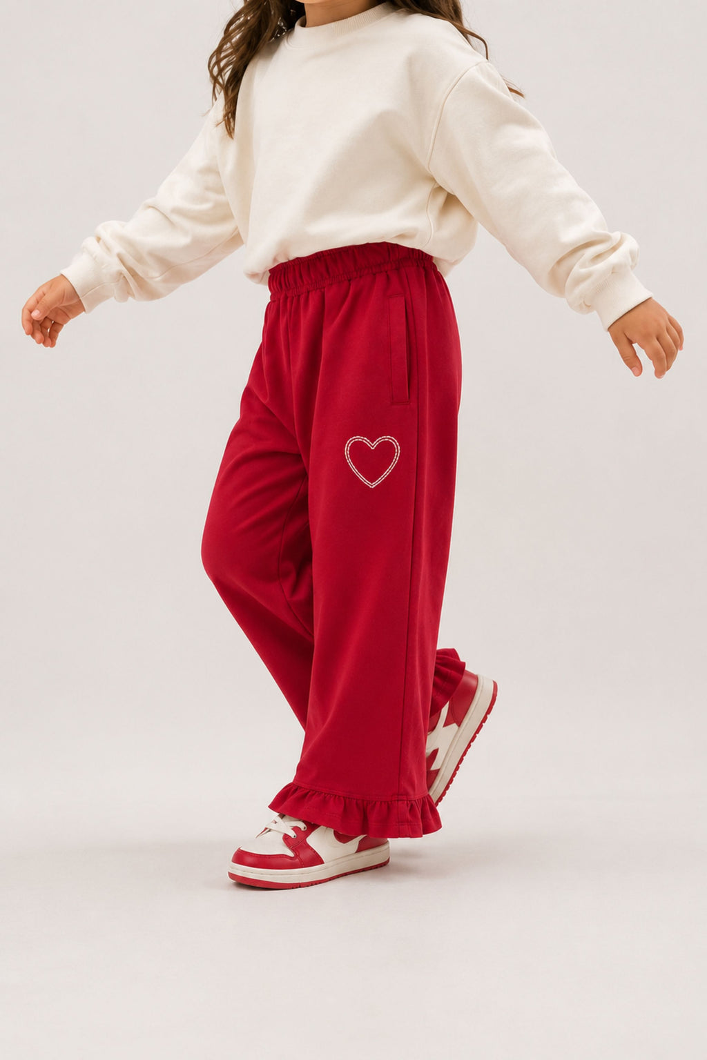 Red palazzo pants with elastic waist, ruffled hem, and heart patch embroidery