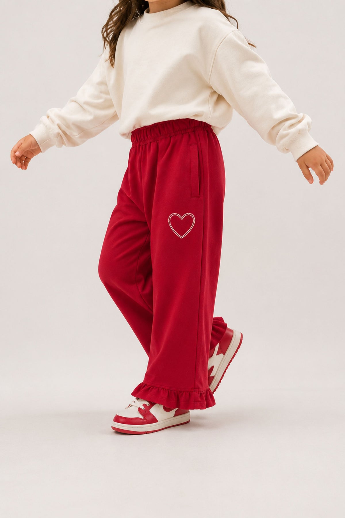 Red palazzo pants with elastic waist, ruffled hem, and heart patch embroidery
