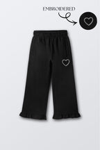 Black flared palazzo pants with small heart embroidery on thigh