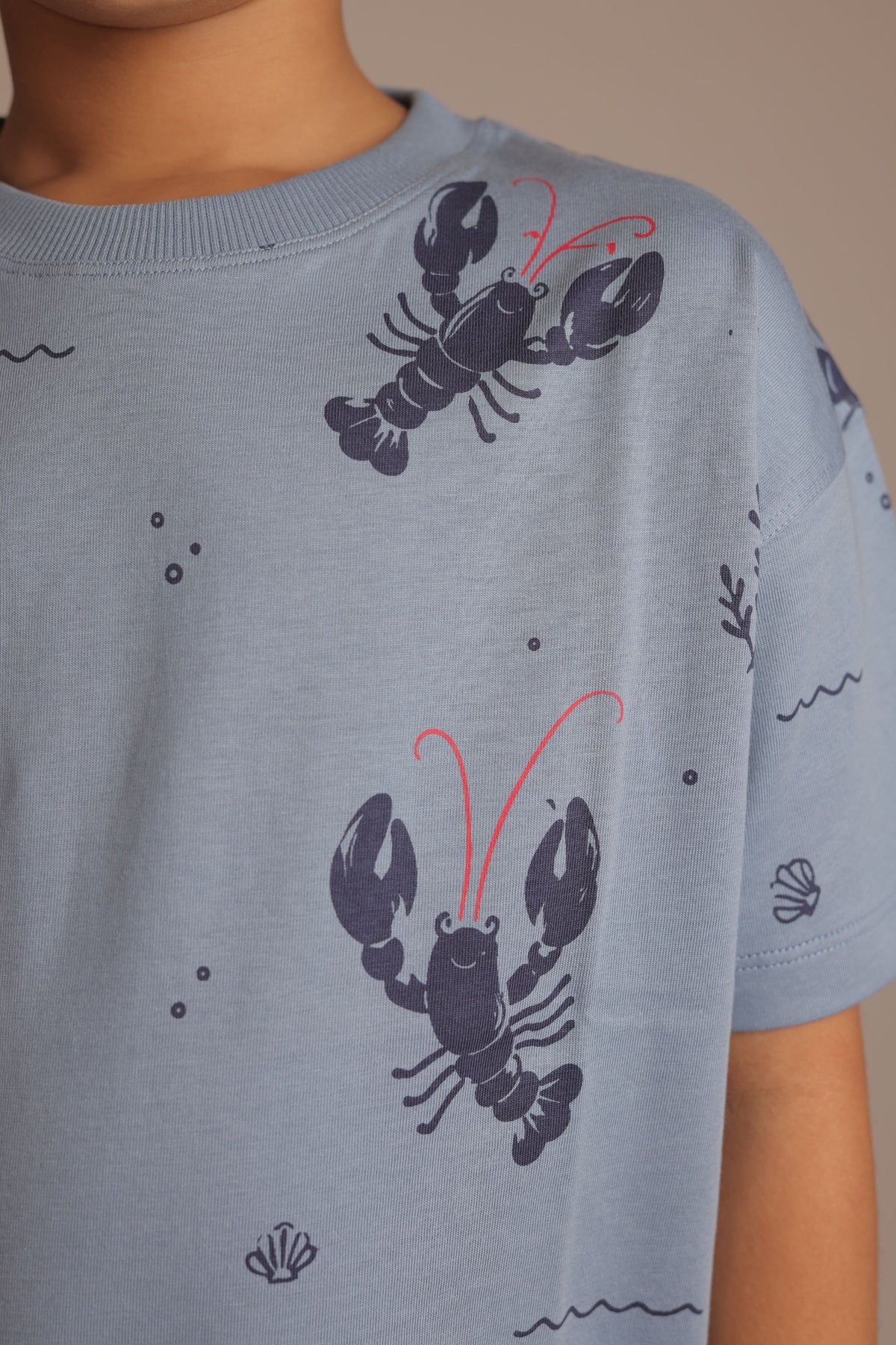 Light blue crew-neck comfort tee with all-over lobster print and red accents