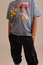 Blue comfort tee close-up of back graphic with red van, bee, plane and sunburst