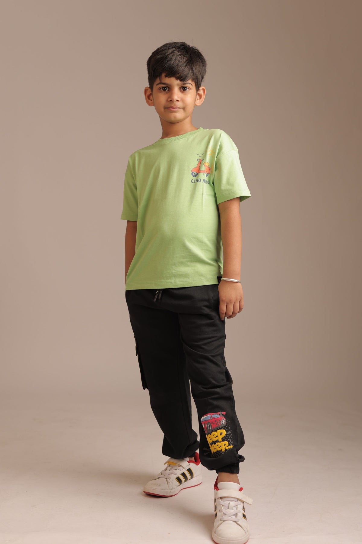Kids green comfort tee with small scooter “CIAO AMICO” logo on chest