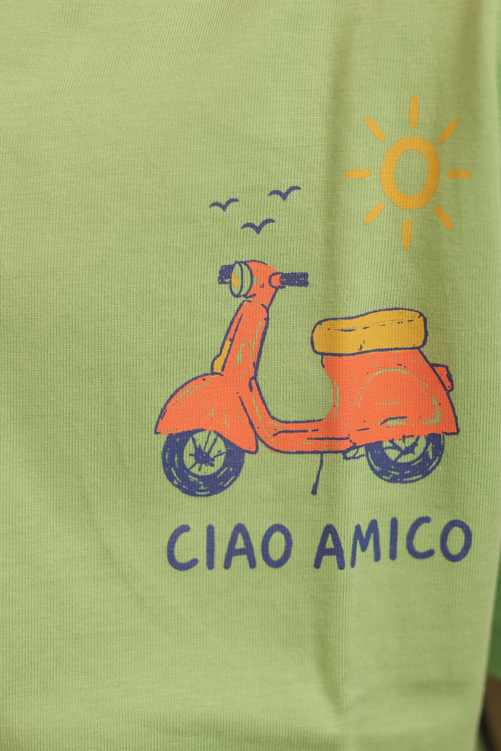Green kids comfort tee with scooter, sun icon, and “CIAO AMICO” front graphic