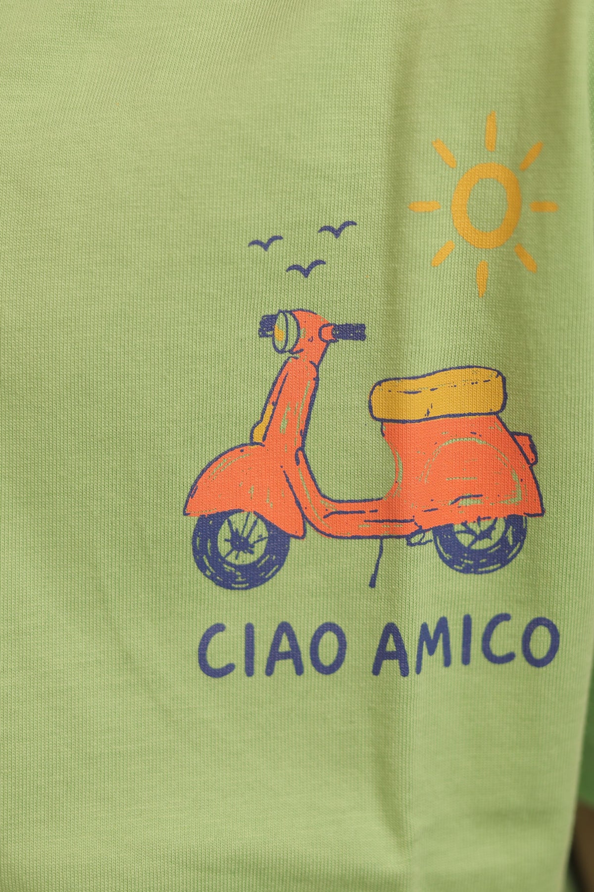 Green kids comfort tee with scooter, sun icon, and “CIAO AMICO” front graphic
