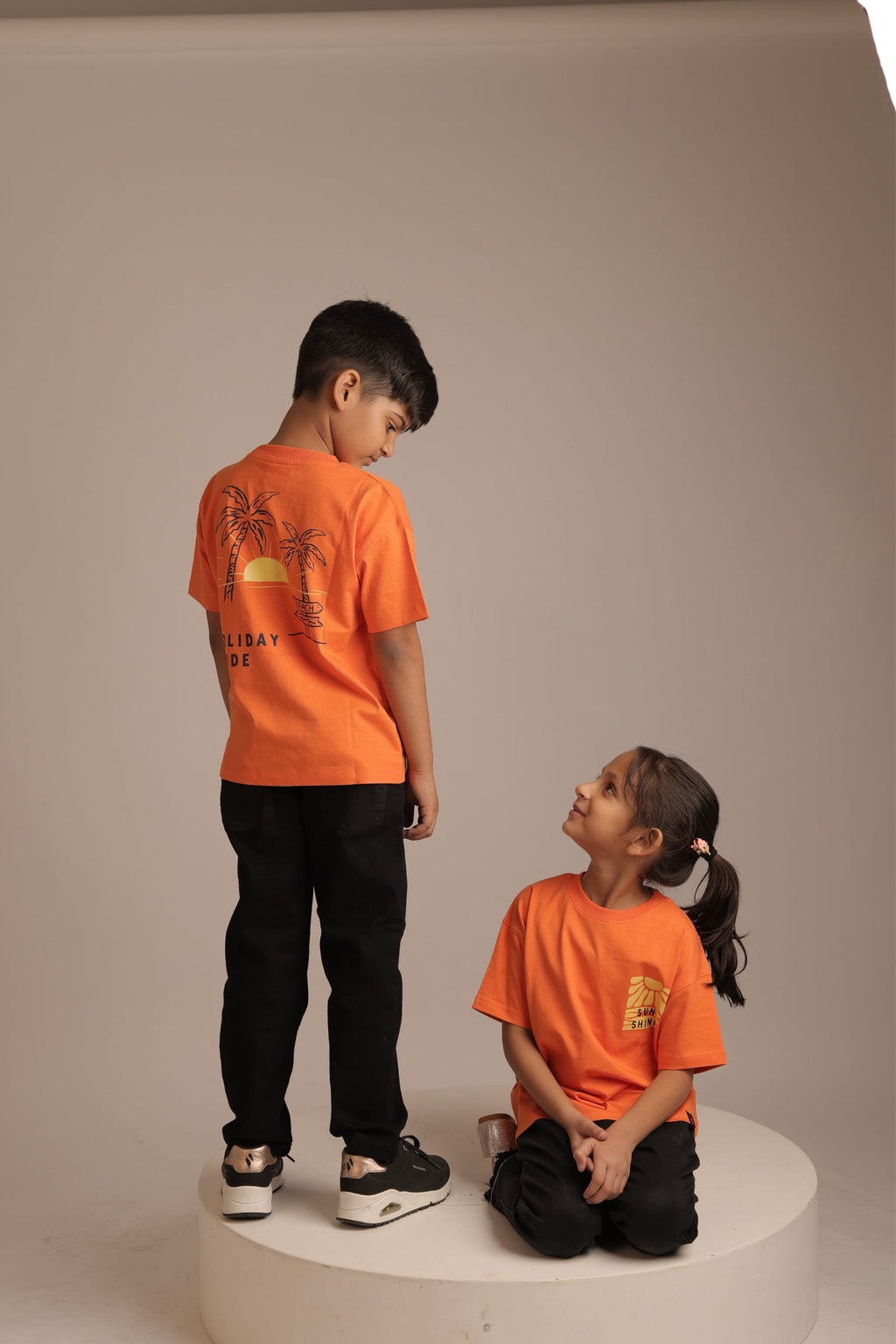 Orange kids' short-sleeve tee with small back palm graphic and 'Holiday Mode' text