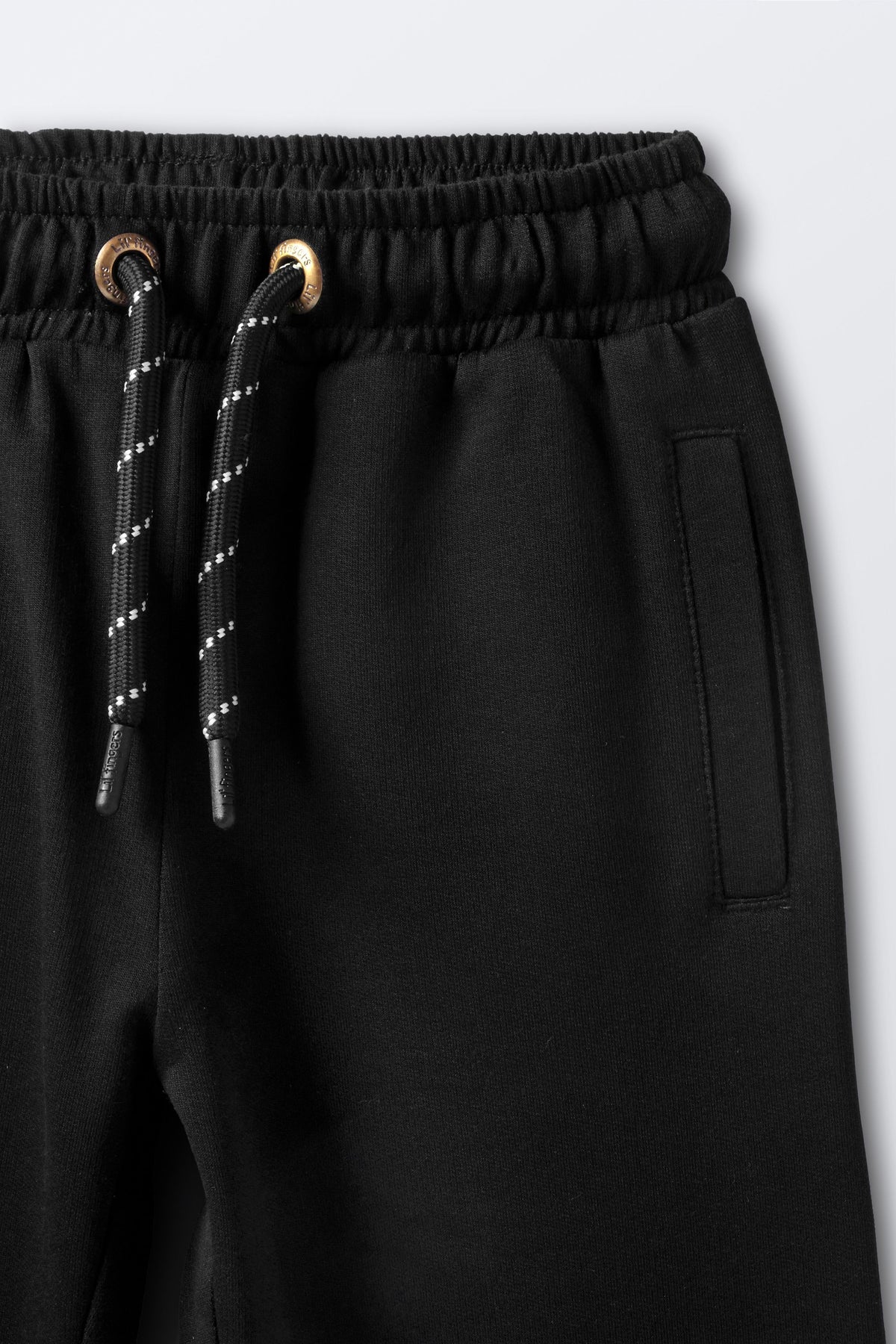 Black joggers with elastic waistband, drawstring, and side pocket detail