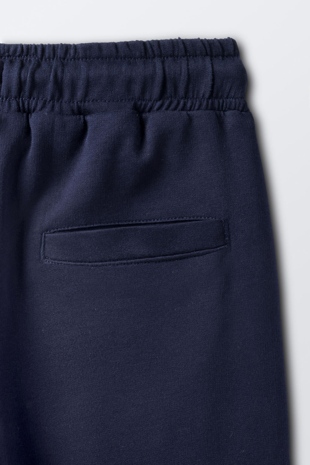 Navy joggers with elastic waistband and front slanted pocket detail