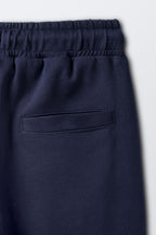 Navy joggers with elastic waistband and front slanted pocket detail