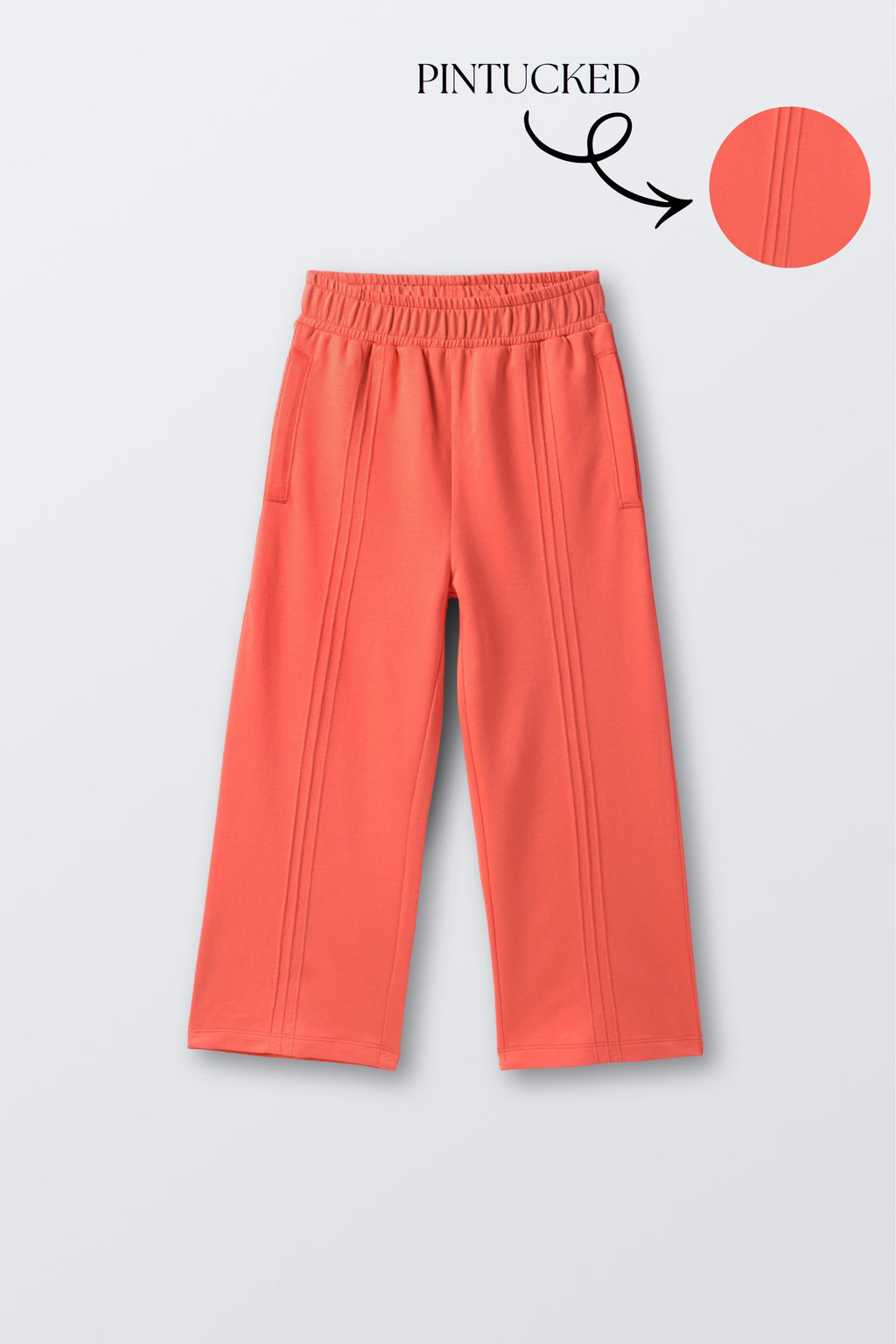 Coral palazzo pants featuring vertical pintucks and elastic waistband