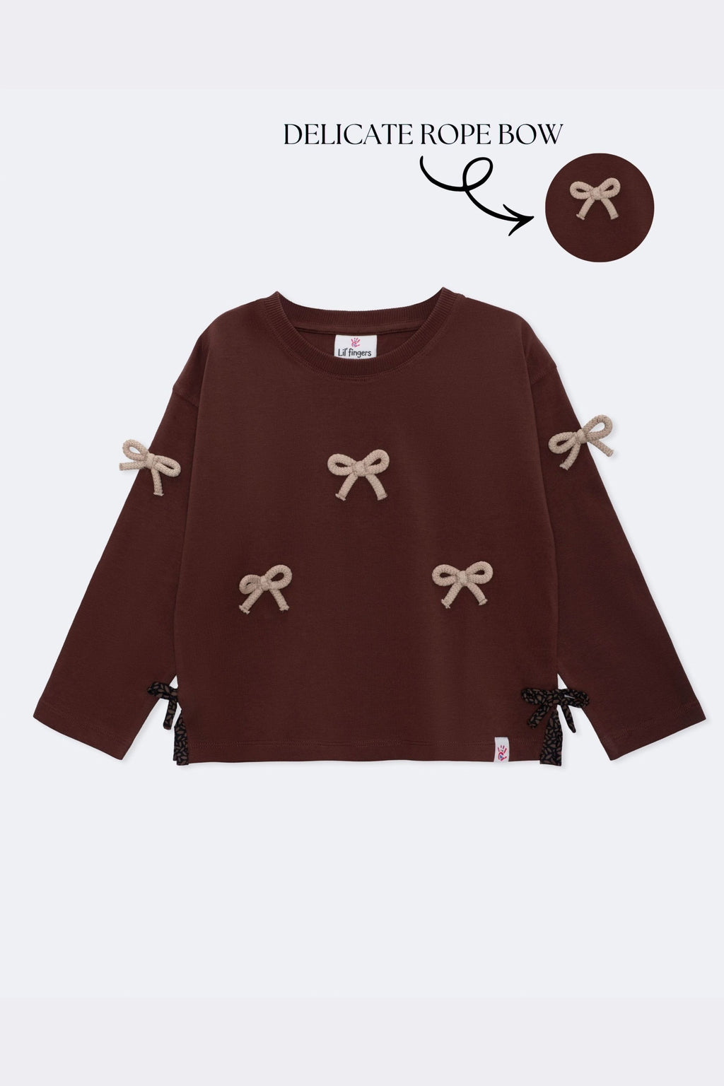 Dark brown long-sleeve kids' tee with beige bow appliques and side ribbon ties