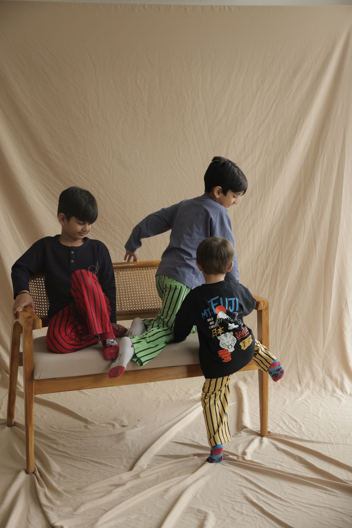 Green striped track pants with elastic waistband and drawstring worn by kids